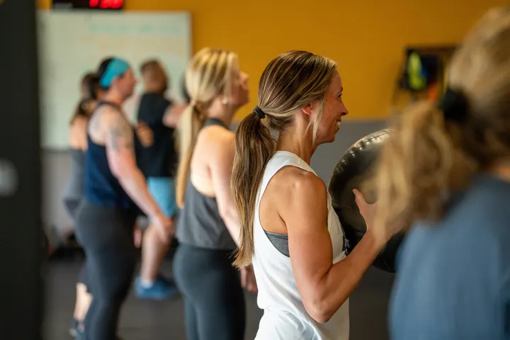 Adults training together with dumbbells during a coached group session at TNT Fitness in Menasha