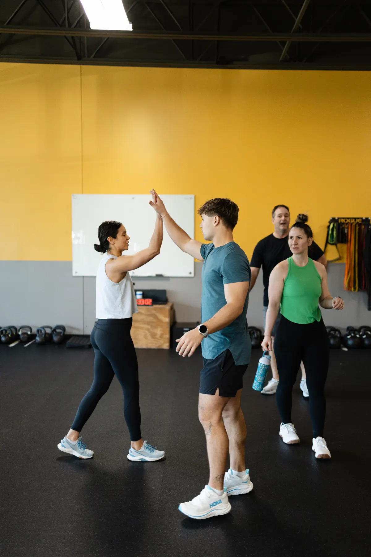 Adults in their fifties lifting weights together during a coached strength session at TNT Fitness