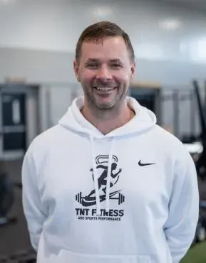 TNT Fitness coach cueing an adult member through a lift in Menasha, Wisconsin