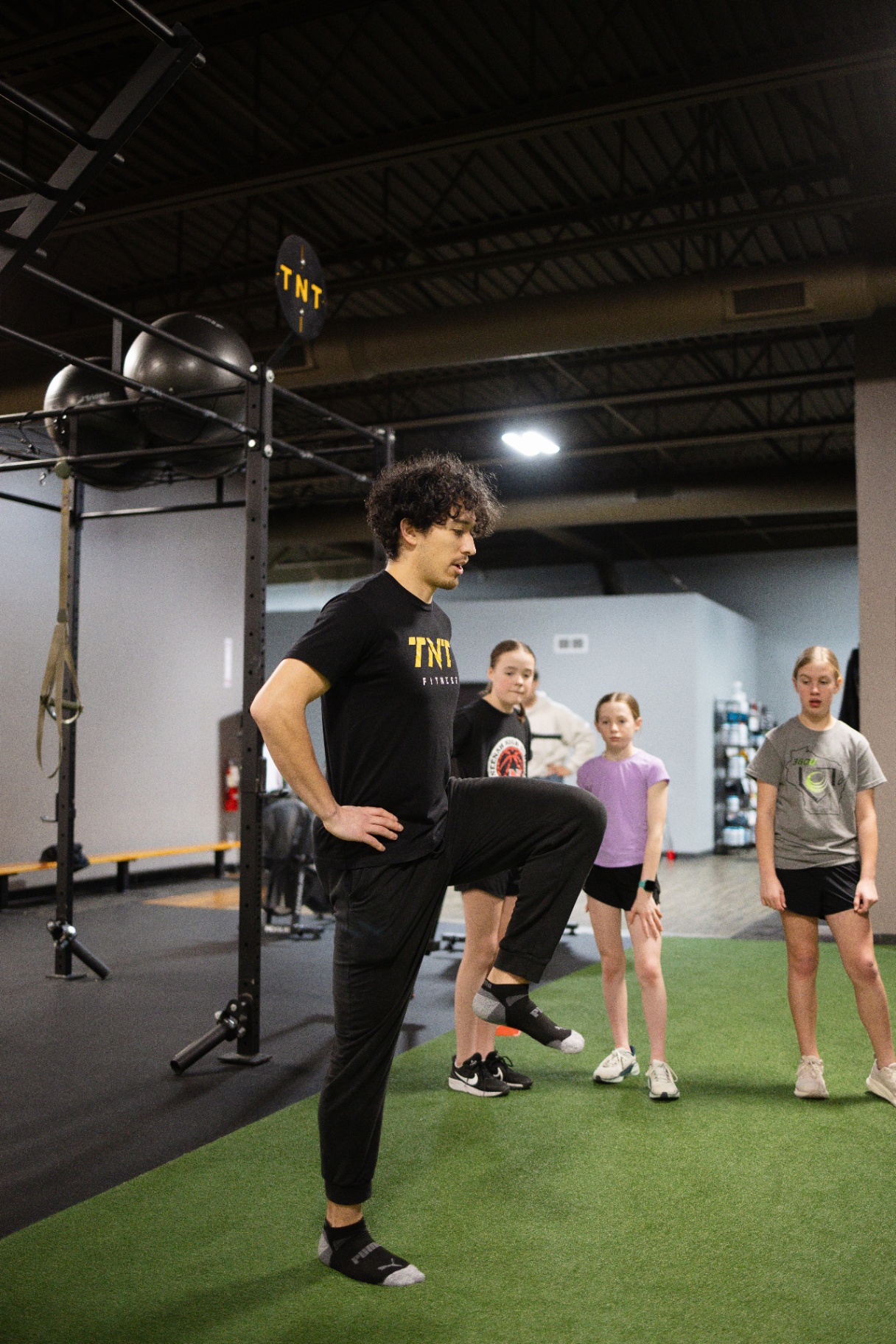 Youth member learning proper lifting technique with a TNT Fitness coach in Menasha, WI